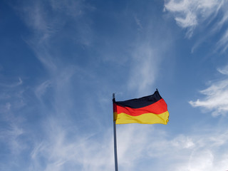 Flag of Germany flying in the wind against blue sky