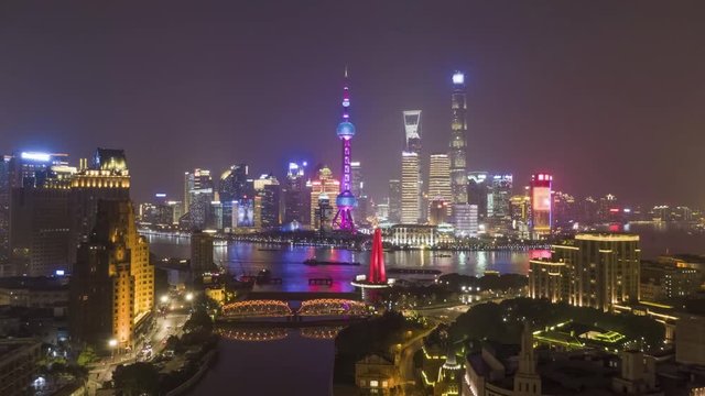 Shanghai Skyline at Night. Urban Lujiazui District, Huangpu River and Waibaidu Bridge. China. Aerial Hyper Lapse, Time Lapse. Drone is Flying Backwards and Upward