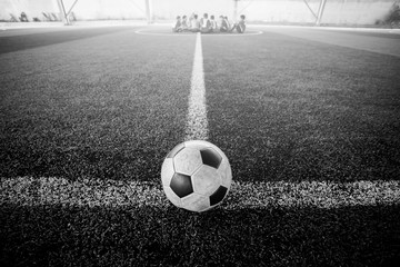 black and white image of football on artificial turf.
