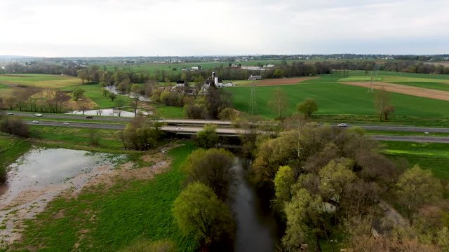 Highway bridge spans across small river in the Pennsylvania countryside, state highway 222 from the air, transportation and travel concept