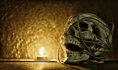 skull still life / Human skull with rope around decorated at halloween party and light candle on dark