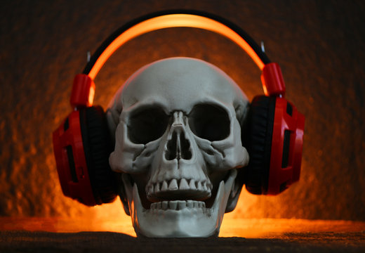 Skull music with headphone / Human skull listening to music earphone decorated at halloween party