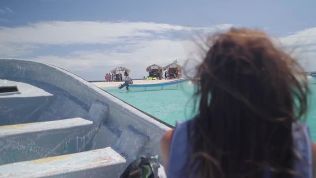 Slow Motion: Boat Comes to Island with Small Huts, Shot Over Woman's Shoulder� - Cayo Arena, Dominican Republic