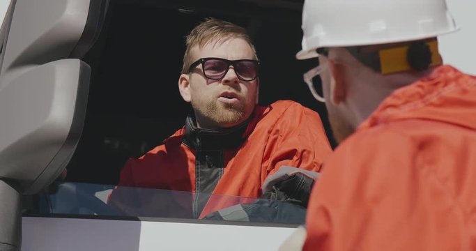 Two male caucasian oil workers discuss work and record operation data of oil and gas process at production plant, Routine daily record.