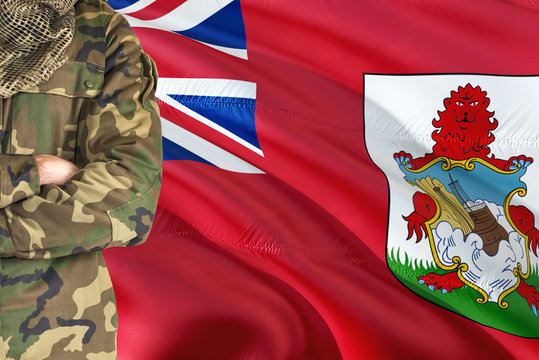 Crossed arms soldier with national waving flag on background - Bermuda Military theme.