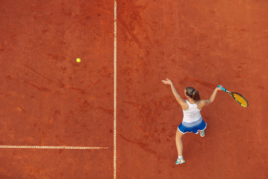 Aerial shot of a female tennis player on a court during match. Young woman playing tennis.High angle view.