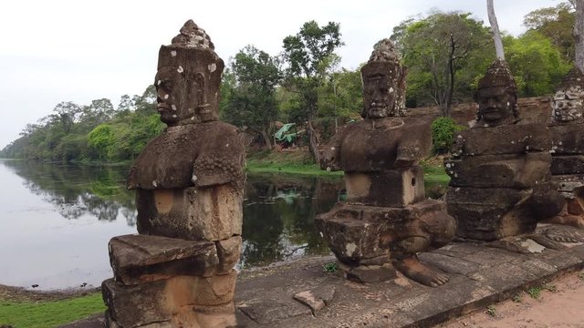 the bridge with the remains of stone figures, "giants" Asuras (evil spirits) and Devas (good spirits), which hold many-headed snakes, the entrance to the temple of Bayon. Cambodia, Angkor Wat temple c