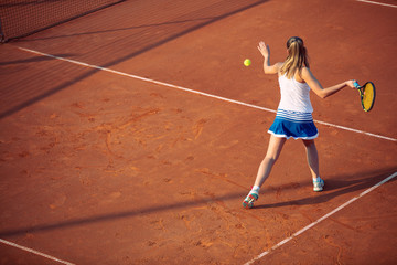 Fototapeta na wymiar Young woman playing tennis on clay. Forehand.