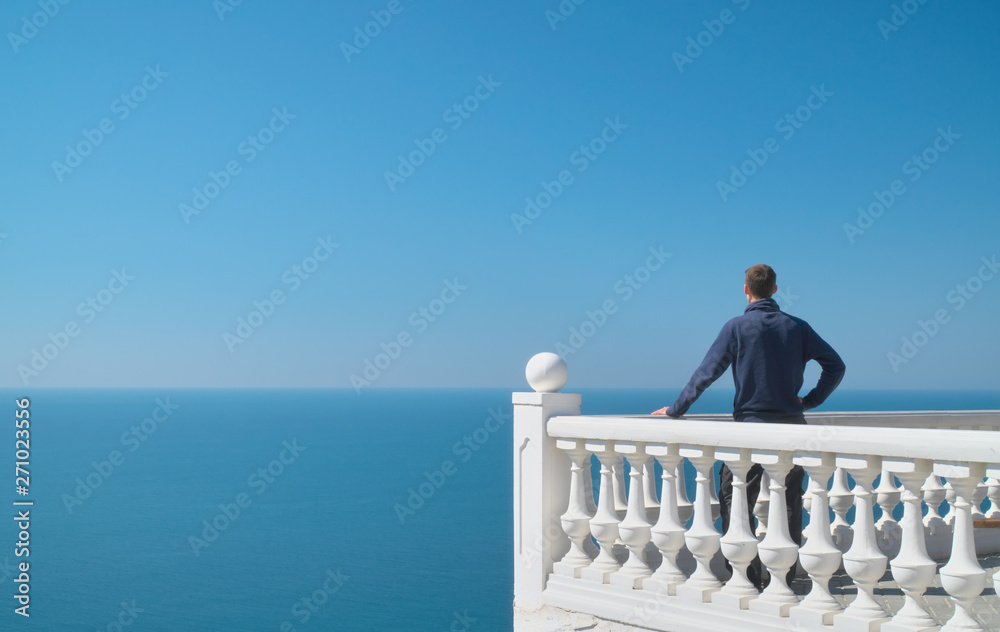 Wall mural man standing on balcony and look on the sea