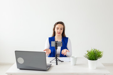 Blogging, broadcast and people concept - woman blogger is talking to the camera for her spectators