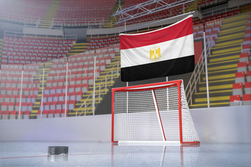 Flag of Egypt in hockey arena with puck and net
