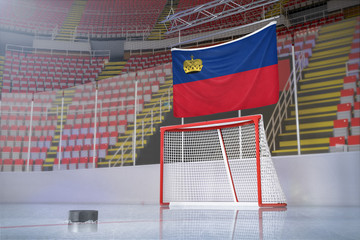Flag of Liechtenstein in hockey arena with puck and net