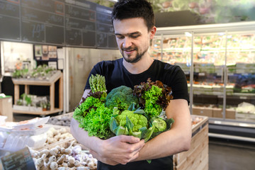 Young man buying vegetables at the market