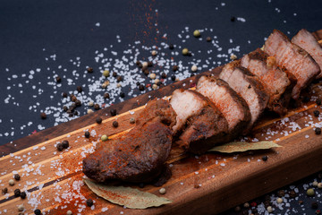 Oven Roasted Pork with spices on wooden cutting board.