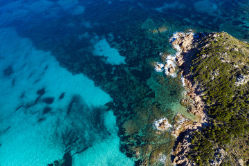Fototapeta na wymiar View from above, stunning aerial view of a green rocky coast bathed by a beautiful turquoise sea. Costa Smeralda (Emerald Coast) Sardinia, Italy.