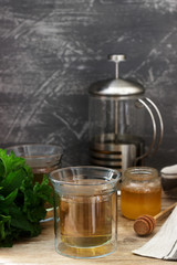 Herbal tea made from mint and lemon balm with honey in glass cups. Rustic style.