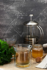 Herbal tea made from mint and lemon balm with honey in glass cups. Rustic style.