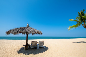 Beach chairs, umbrella and palms on sandy beach near sea. island in Phuket, Thailand. Travel inspirational, Summer holiday and vacation concept for tourism relaxing.