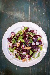 Salad of young beets, mustard leaves, radish nuts and garlic, top view
