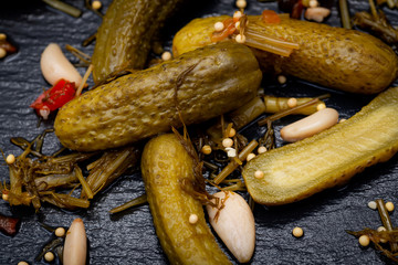 Extra Fine Cornichons - minuscule sour French pickles on natural stone background. Mini French style Gherkin Cucumbers.