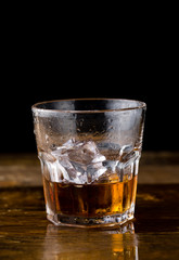 Glass of whiskey on wooden background, close up