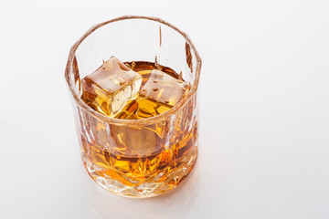 Glass of scotch whiskey on white background