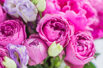 Texture background of flowers, peonies, roses. Arrangement of flowers in a hat box. Bouquet of peonies, eustoma, spray rose in a pink box with an oasis on a white background