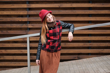 Sensual woman in a red bowler hat with long hair on wooden background. Autumn fashion.
