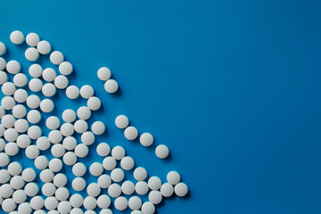 Assorted pharmaceutical medicine pills, tablets and capsules.Pills background. Heap of assorted various medicine tablets and pills different colors on blue background. Health care.Top view.Copy space