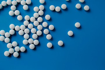 Assorted pharmaceutical medicine pills, tablets and capsules.Pills background. Heap of assorted various medicine tablets and pills different colors on blue background. Health care.Top view.Copy space
