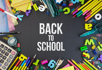 Colorful Stationery items on a black board with back to school typing