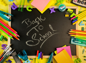 Back to School concept school and office supplies on a yellow background all stationery items with black board