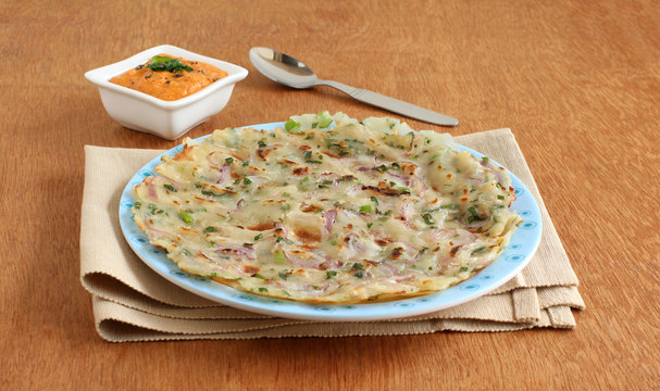 Masala rice roti, an Indian vegetarian bread with onion as a main ingredient, which is typically made for breakfast or lunch, with onion-tomato chutney as a side dish.