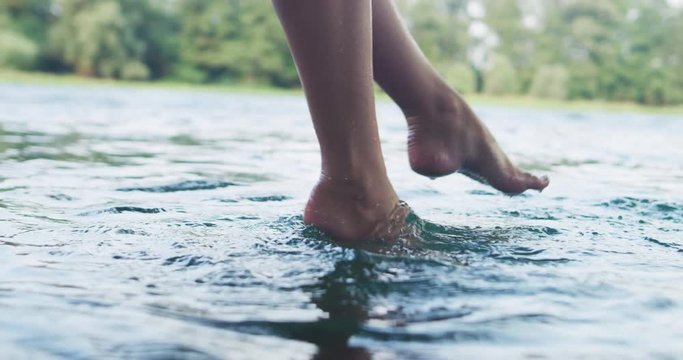 Young blonde woman resting on hammock while enjoying nature on the river bank