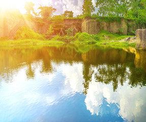Reflection of Sky and Cloud in Blue Water Lake with Big Rock Cliff Around It and Vision of Yellow Sun Beam. Concept of Happiness and Clear and Healthy State of Mind.