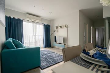 minimal apartment interior design with blue sofa and wooden dining table home interior background