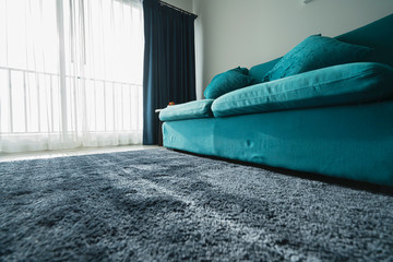 close up blue sofa and fur carpet rug near window family room interior background