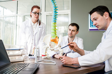 Fototapeta premium Doctors team having medical council in hospital. Discussing medical issues. Spine fixation systems