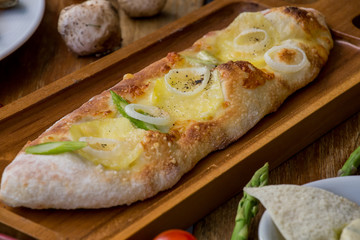 Onion flatbread on wooden chopping board. Italian Pizza flatbread