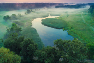 Early misty morning, sunrise over the lake. Rural landscape in summer. Aerial view