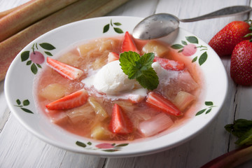 Rhubarb soup with strawberries and ice cream in