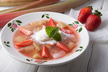 Rhubarb soup with strawberries and ice cream in
