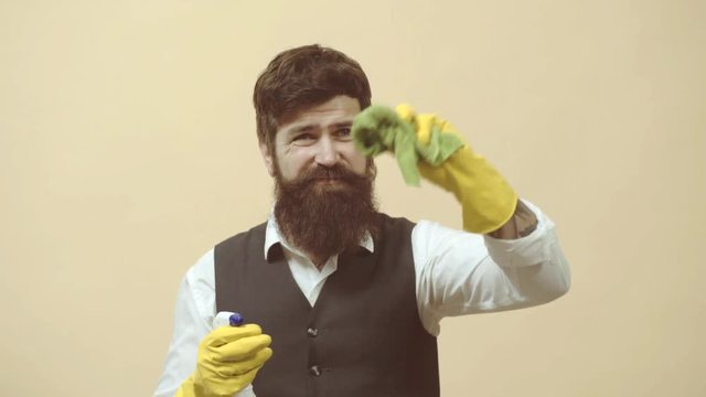 Cleaning service. Man with cleaning agents working. Portrait of man with cleaning equipment cleaning the house. Portrait of a bearded man with sponge and spray ready to clean windows.