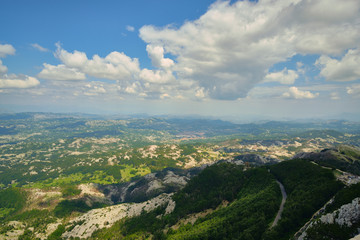 View from the mountain peak Lovchen on a sunny day. Blue sky with clouds, a bird's eye view.