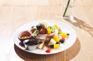 Breakfast composition with fresh pancakes and berries on wood background.