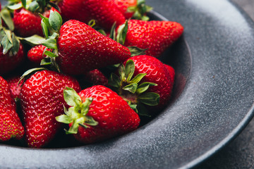 Fresh strawberries on a dark kitchen table.