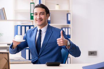 Young handsome employee in the office 