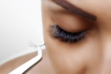Eyelash Extension Procedure. Woman Eye with Long Blue Eyelashes. Ombre effect. Close up, selective focus. - 271043799