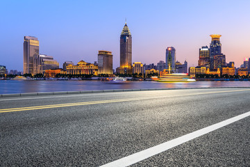 Fototapeta na wymiar Shanghai city skyline and empty asphalt highway at sunset
