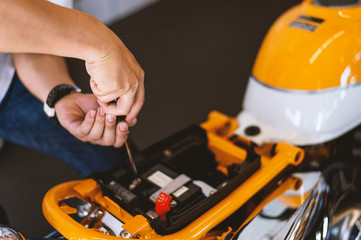 motor style. mechanic fixing motorcycle with soft-focus and over light in the background